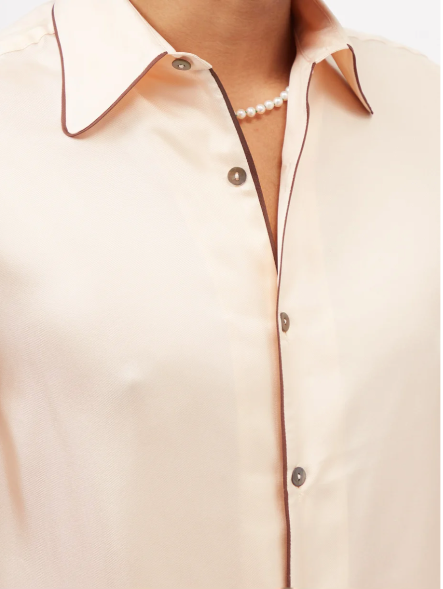 Close up of 73 London piped trim silk satin shirt